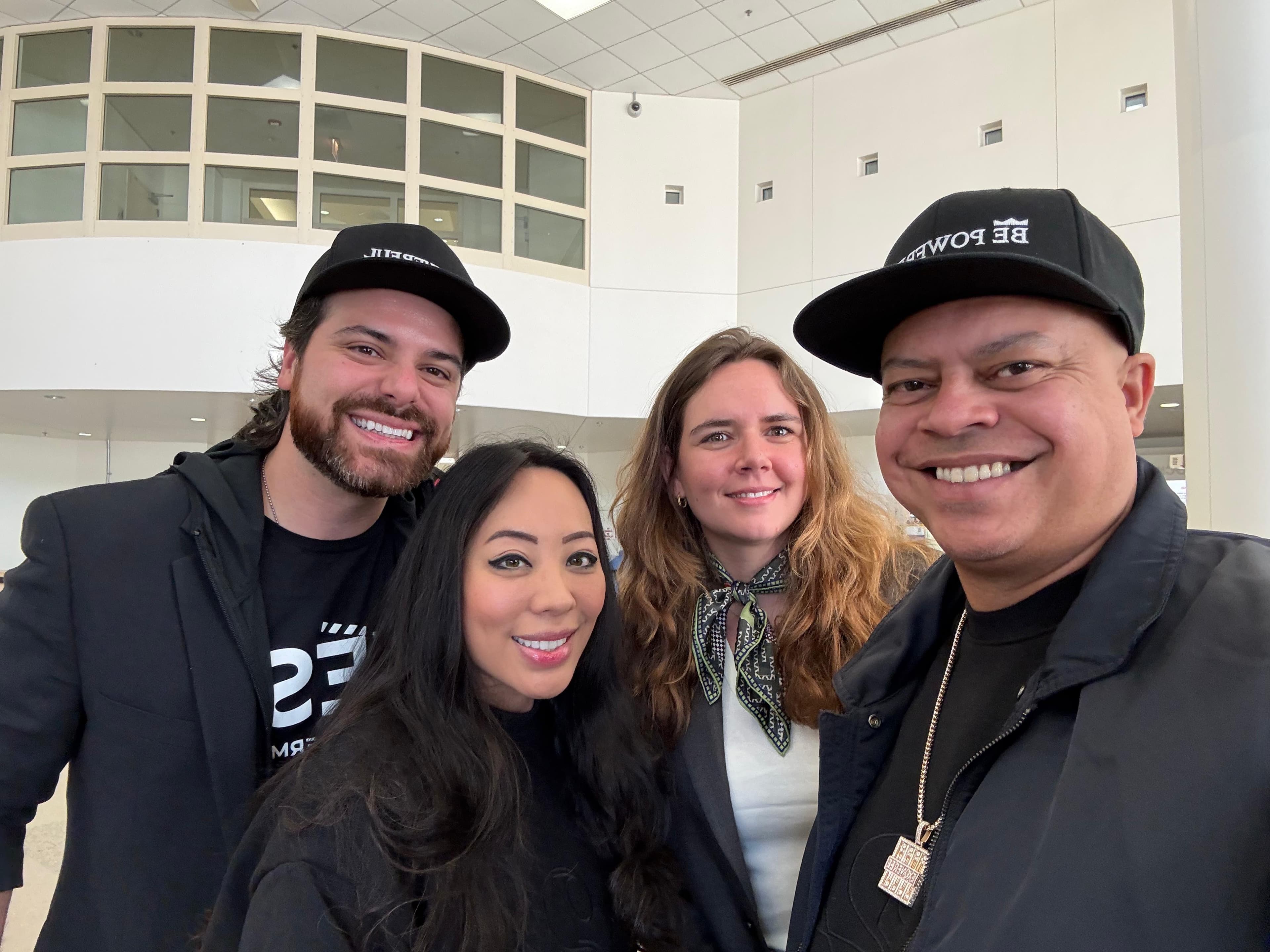 Ein Selfie von 4 Personen vor dem Eingang des Cook County Department of Corrections in Chicago. Zwei davon tragen eine Kappe mit der Aufschrift "BE POWERFUL"